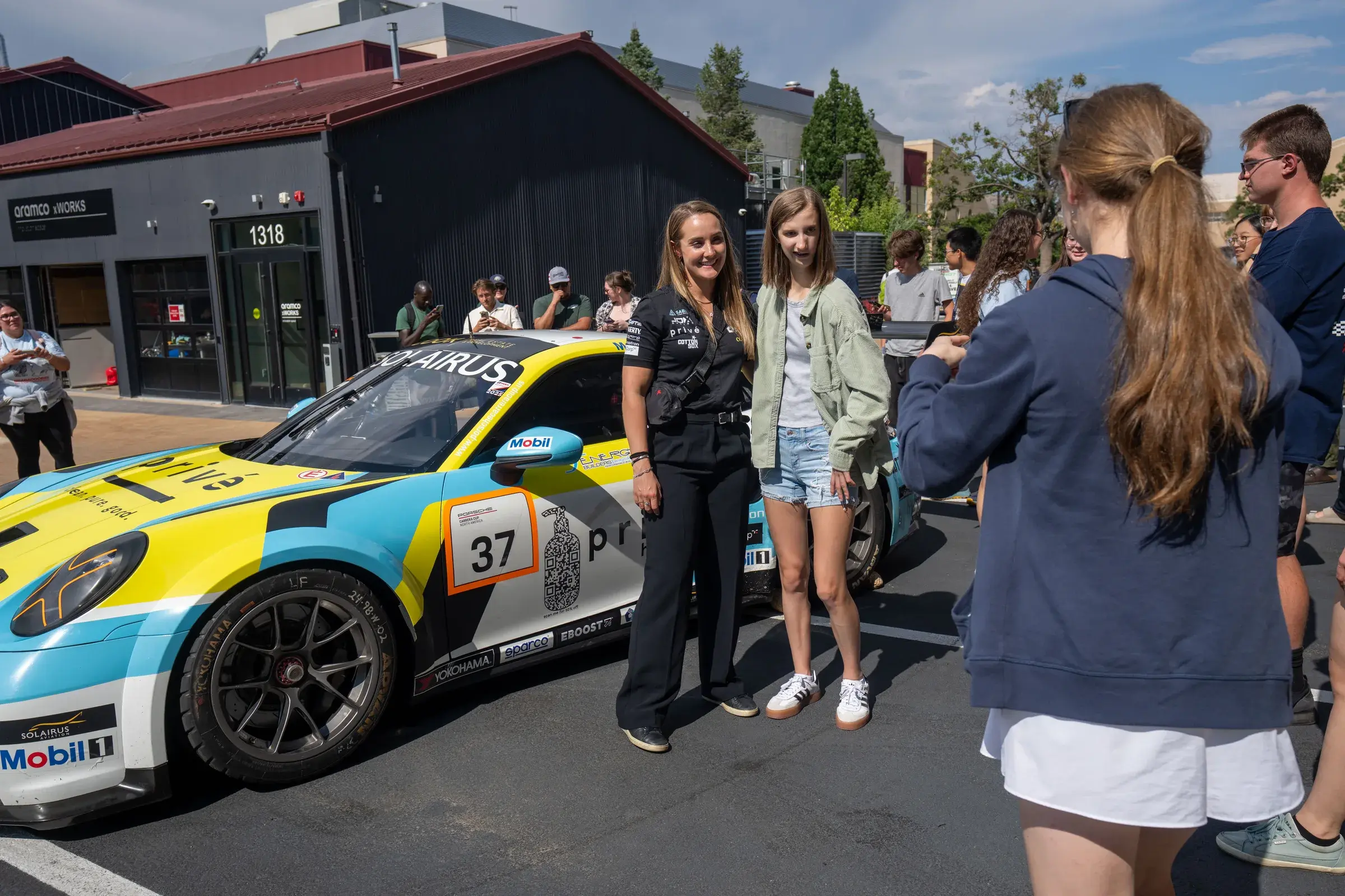 Sabré and a student pose in front of her 2025 Porsche at the Colorado School of Mines.