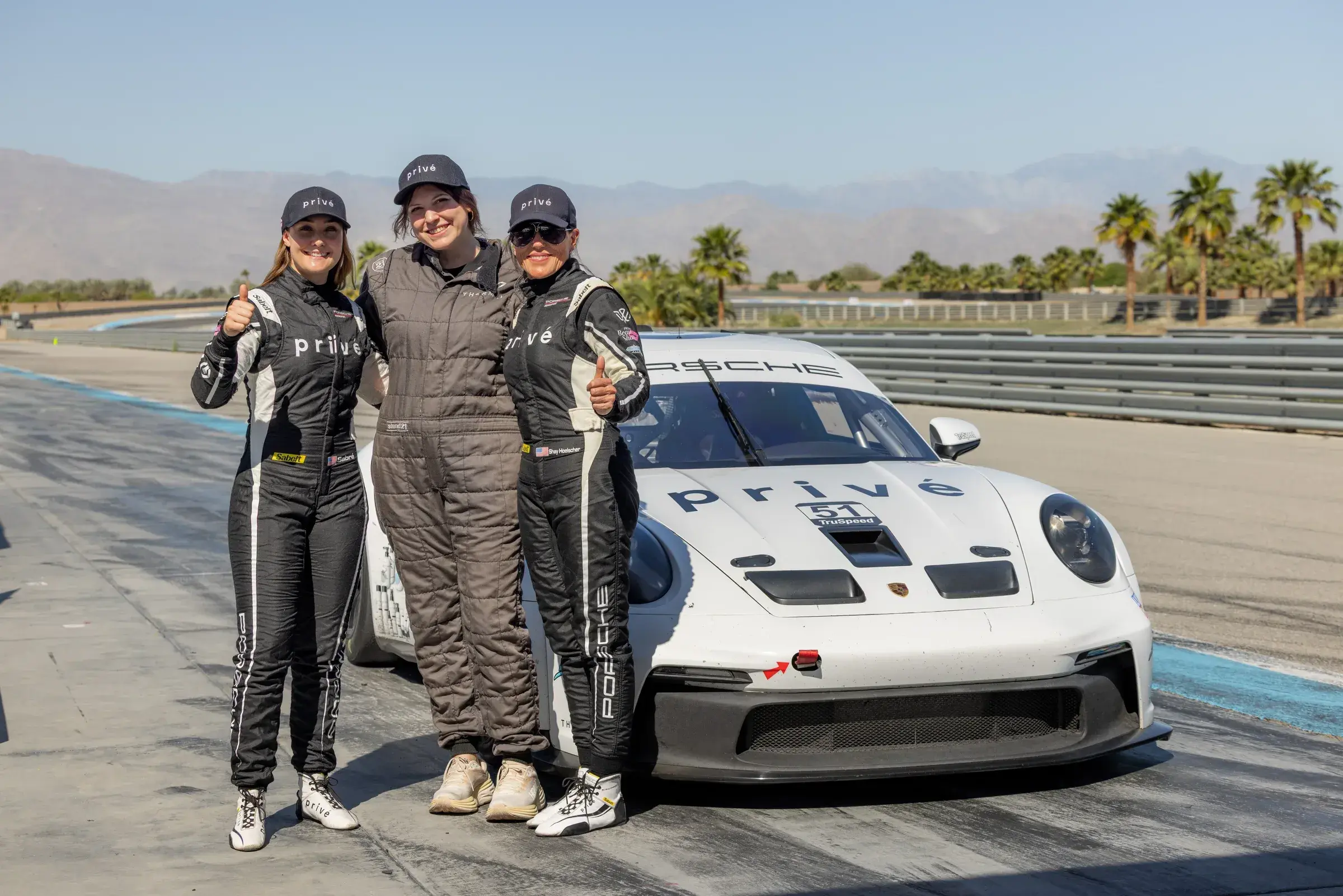 Sabré and Shay pose with a Privé guest in front of the Porsche before the ride session.