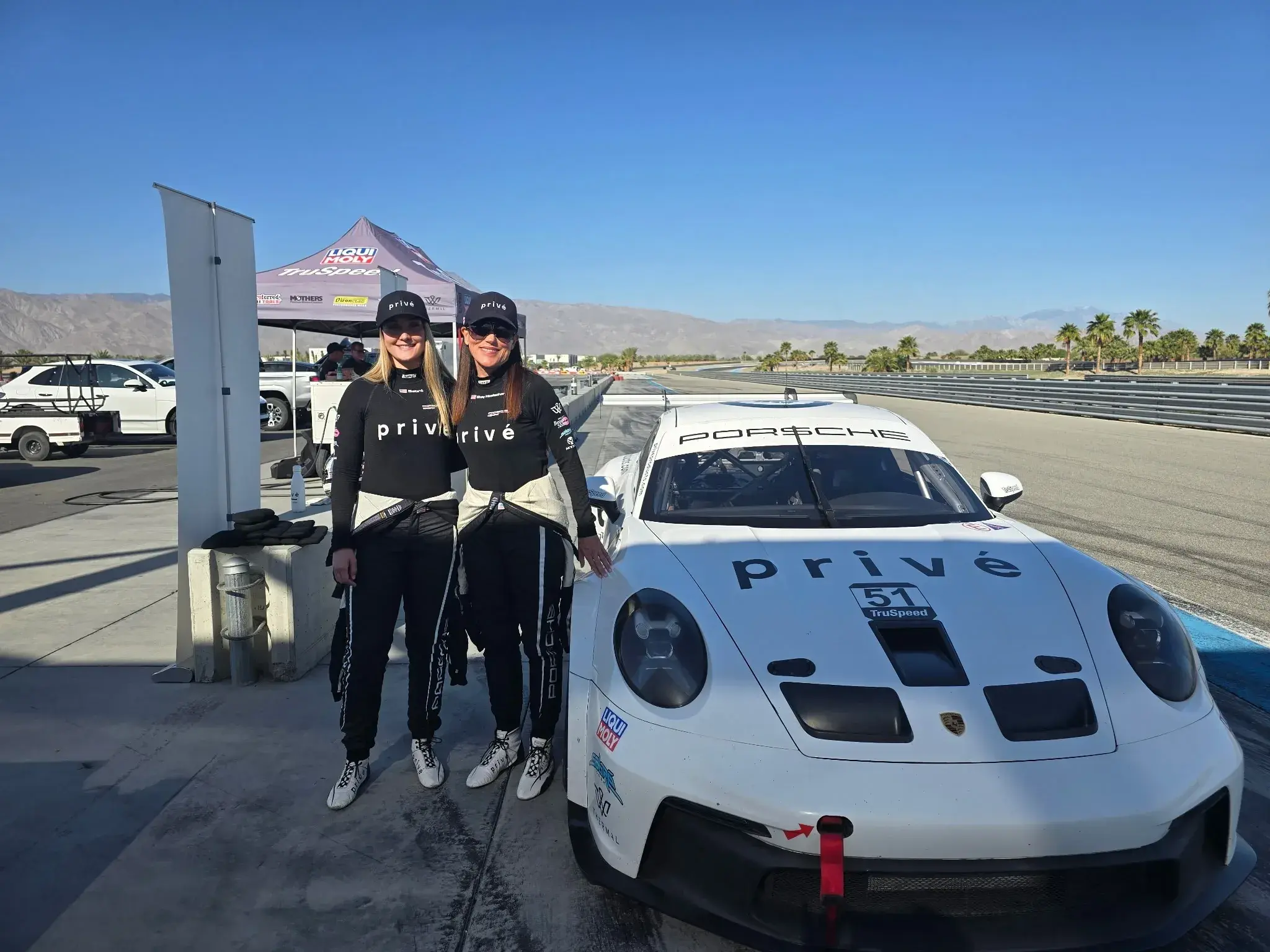 CEO and founder Shay Hoelscher and Sabré pose in front of the Privé Porsche.